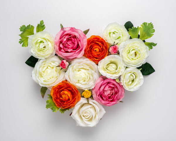 Heart shaped bouquet of beautiful rose flowers on white background. Minimal holiday concept.