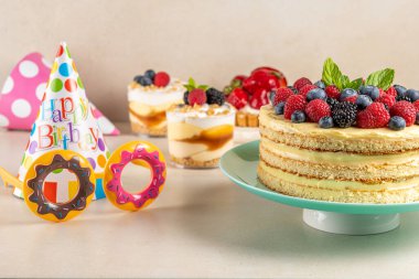 Taze dutlu ev yapımı pasta ve parlak arka planda doğum günü şapkası.. 