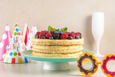 Taze dutlu ev yapımı pasta ve parlak arka planda doğum günü şapkası.. 