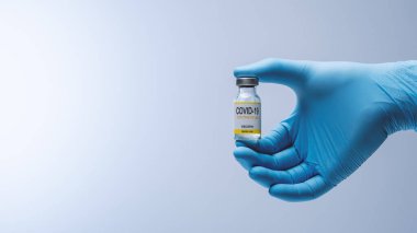Doctor in blue latex gloves holding glass vial with medicine. Vaccination, immunization, treatment to Covid 19 Corona Virus infection. Healthcare And Medical concept.