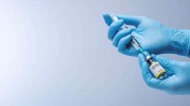 Doctor in blue latex gloves fill in syringe with vaccine from glass vial. Vaccination, immunization, treatment to Covid 19 Corona Virus infection. Healthcare And Medical concept.