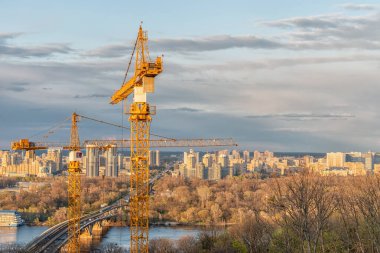 Kiev 'deki inşaat sahasında şehrin arka planında vinçler var.