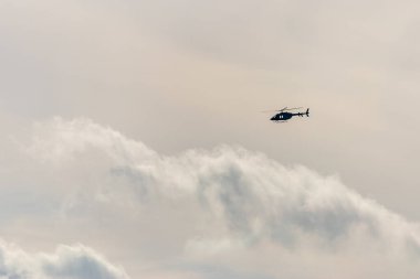 Dramatik gökyüzü arka planında uçan helikopter.
