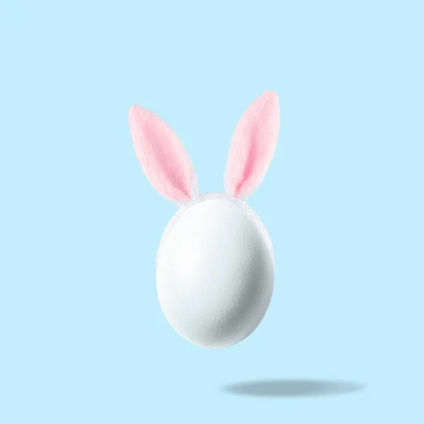 White Egg Pink Bunny Ears Pastel Blue Background Easter Minimal — ストック写真
