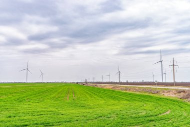 Rüzgar türbinleri yeşil alanda elektrik üretiyor. Yeşil enerji üretimi kavramı.