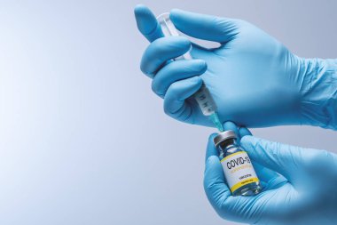 Hands in blue latex gloves with vaccine from glass vial. Healthcare And Medical concept.