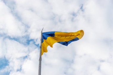 Ukrayna bayrağı gökyüzüne karşı rüzgarda dalgalanıyor.