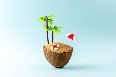 Hindistan cevizi ve güneş şemsiyesinden yapılmış tropik plaj konsepti. Yaratıcı asgari yaz arkaplanı.