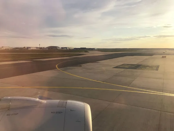 View from the airplane porthole on the airport at sunset.