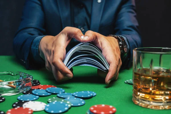 Poker player shuffles the poker cards in casino.