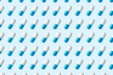 Mavi arka planda kapsülleri olan yaratıcı desen. Asgari tıbbi konsept.