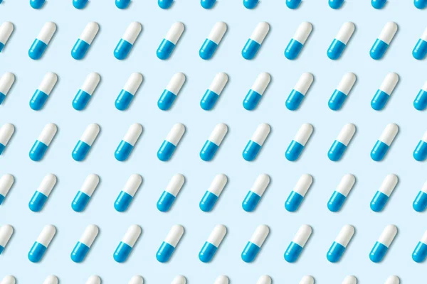 Mavi arka planda kapsülleri olan yaratıcı desen. Asgari tıbbi konsept.
