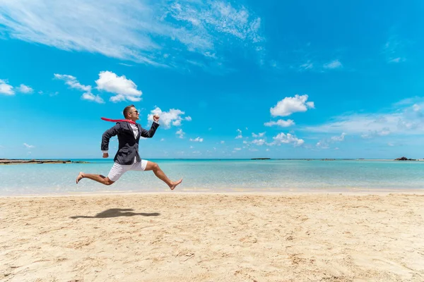 Funny businessman runs from office work on the beach. Summer holiday concept.