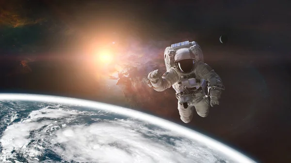 Spaceman is flying in outer space on Earth background. Elements of this image furnished by NASA.