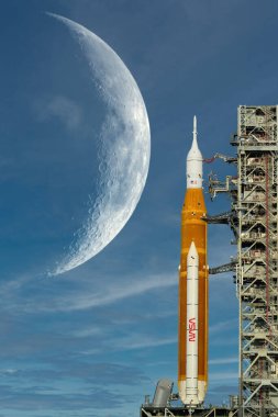 Orion uzay aracı fırlatma rampasında ve büyük ay arka planda. Güneş sistemini araştırmak için Artemis uzay programı. Bu görüntünün elementleri NASA tarafından desteklenmektedir.
