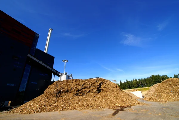 Bio power plant with storage of wooden fuel against blue sky — Stock Photo, Image