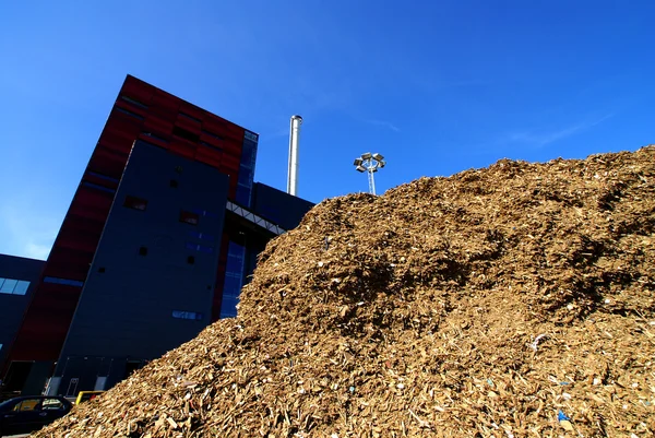 Biokraftwerk mit Holzbrennstofflagerung vor blauem Himmel — Stockfoto