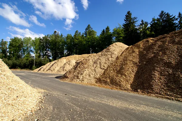 Lagring av träbränsle mot blå himmel — Stockfoto