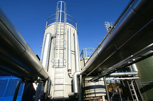 Zona industrial, tuberías de acero y válvulas contra el cielo azul — Foto de Stock