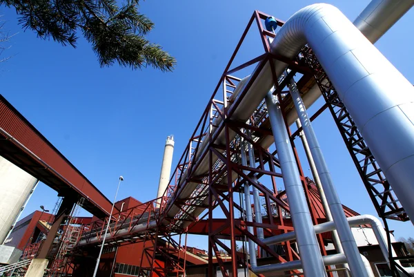 Industriële zone, stalen pijpleidingen en kleppen tegen blauwe lucht — Stockfoto