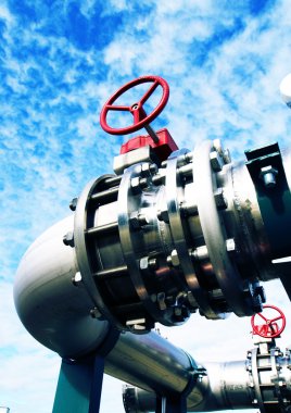 Mavi gökyüzüne karşı sanayi bölgesi, çelik boru hatları ve vanalar