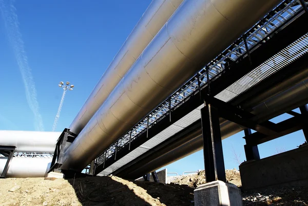 Industriële zone, stalen pijpleidingen en kleppen tegen blauwe lucht — Stockfoto