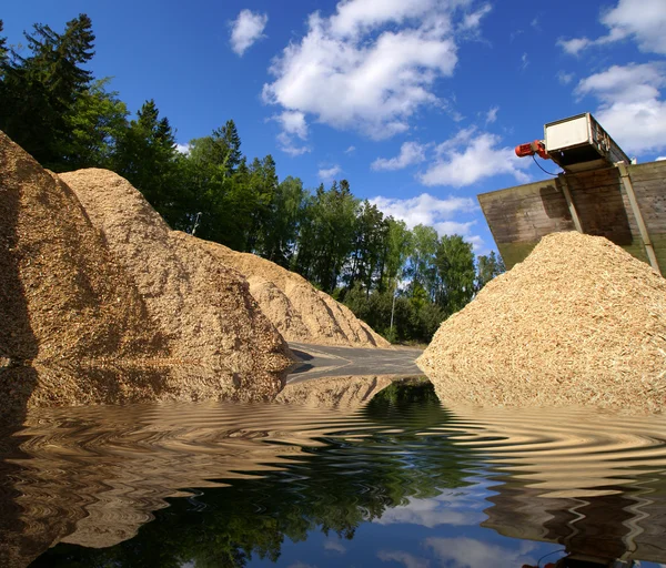 Lagerung von Holzbiomasse gegen blauen Himmel mit Reflexion — Stockfoto