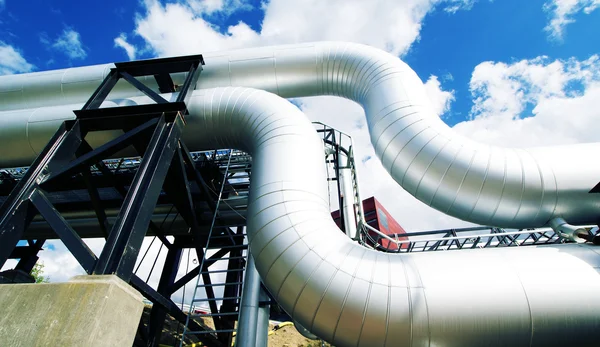 Industrial zone, Steel pipelines and valves against blue sky Stock Photo