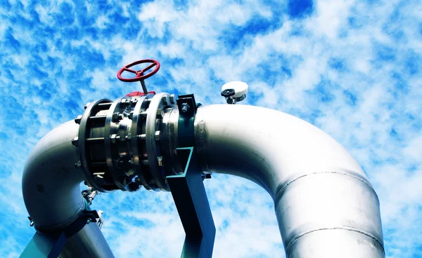 Zona industrial, tuberías de acero y válvulas contra el cielo azul — Foto de Stock