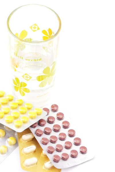 Vaso de agua y pastillas aisladas en blanco —  Fotos de Stock