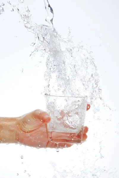 Botella de agua en la mano, en un spray de gotas de agua — Foto de Stock