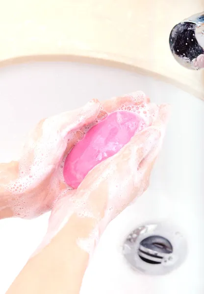 Mãos cobertas com sabão a ser lavado na pia — Fotografia de Stock