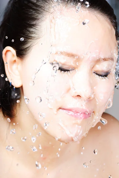 Piękna kobieta z mokra twarz z kropli wody — Zdjęcie stockowe
