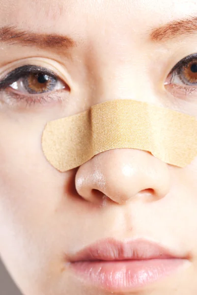 Woman putting a band-aid on her arm isolated over white — Stock Photo, Image