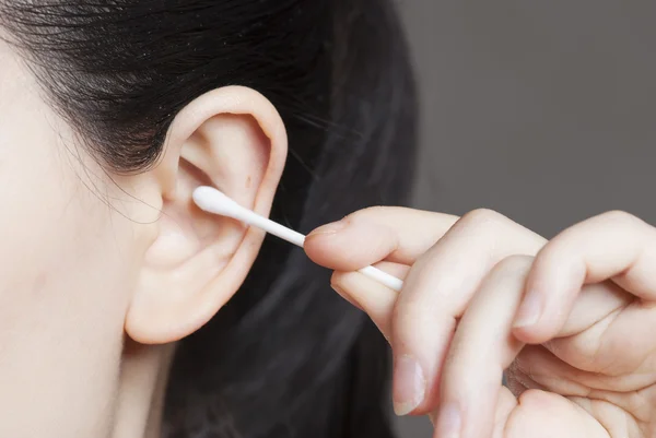 Tamponi di cotone e orecchio umano primo piano su sfondo bianco — Foto Stock