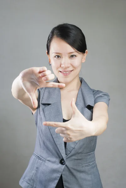 图片中可爱的女人用手指创造一个框架 — 图库照片
