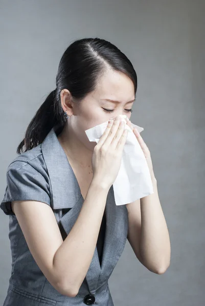 Young woman has a cold and holding a tissue Stock Image