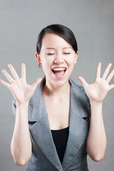 Happy Asian woman with her arms in the air cheering Stock Image