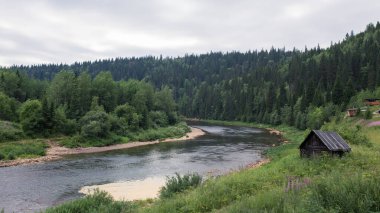 Ural eteklerinin yeşil ormanlarının arasındaki nehir.