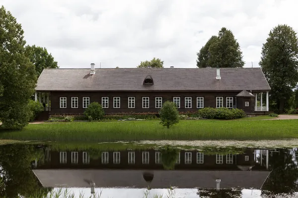 Dlouhý Jednopatrový Tmavý Dům Bílými Okny Odráží Jezírku — Stock fotografie