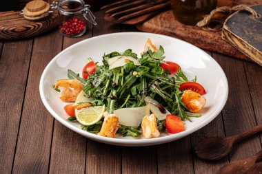 Ahşap zemin üzerinde karides olan Arugula salatası.