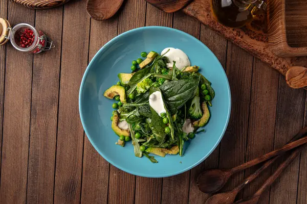 Avokado ve bezelyeli yeşil sağlıklı ıspanak salatası. — Stok fotoğraf