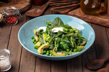 Avokado ve bezelyeli yeşil sağlıklı ıspanak salatası.