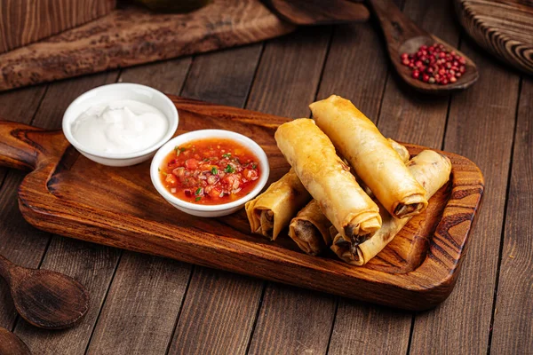 Spring rolls with salsa sauce and sour cream