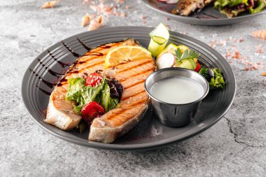 Beyaz soslu ızgara somon bifteği ve salata.