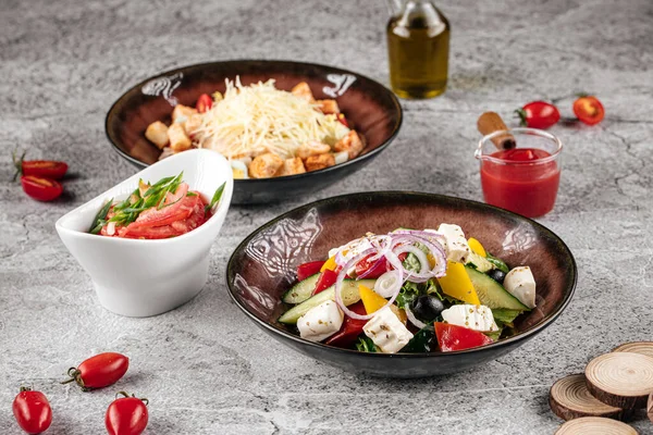 Verschiedene appetitliche Salate griechisch und caesar — Stockfoto
