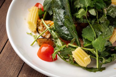 Ahşap zemin üzerinde karides olan Arugula salatası.