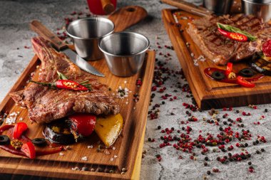 Gri arka planda çeşitli ızgara biftekler