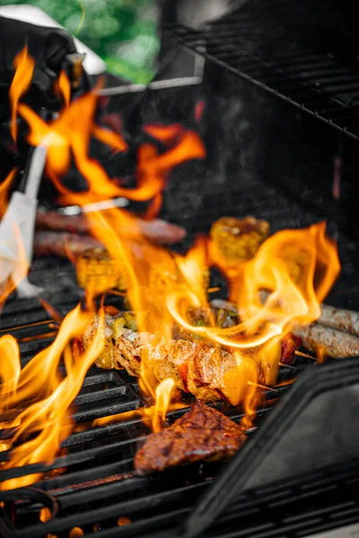 Сосиски на гриле и мясо с пламенем — стоковое фото