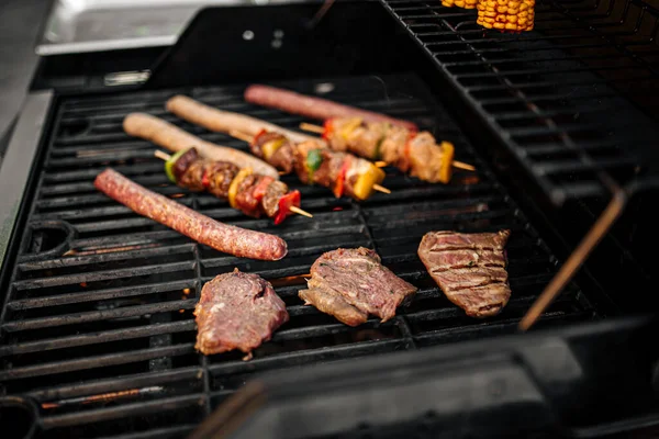 Griller des saucisses et des brochettes sur un barbecue — Photo